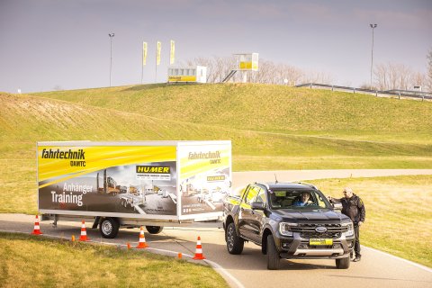 Pick-up Truck mit Anhänger auf Fahrtechnik-Gelände