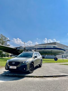 Subaru Auto vor ein Flugzeug.