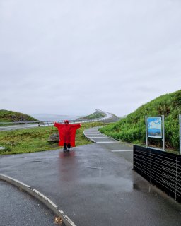 Regen unterwegs in Norwegen. Sabine mit einen Roten Poncho