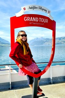 Frau beim Grand Tour Switzeland Schild.