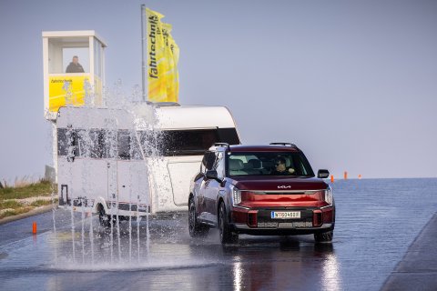 Kia EV9 mit Wohnwagen beim Ausweichen vor Wasserwand