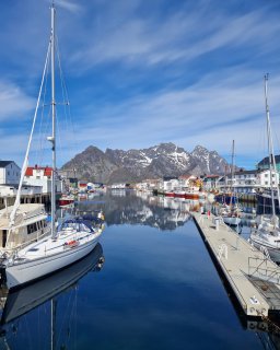 Hafen mit Boote und Bergen im Hintergrund.